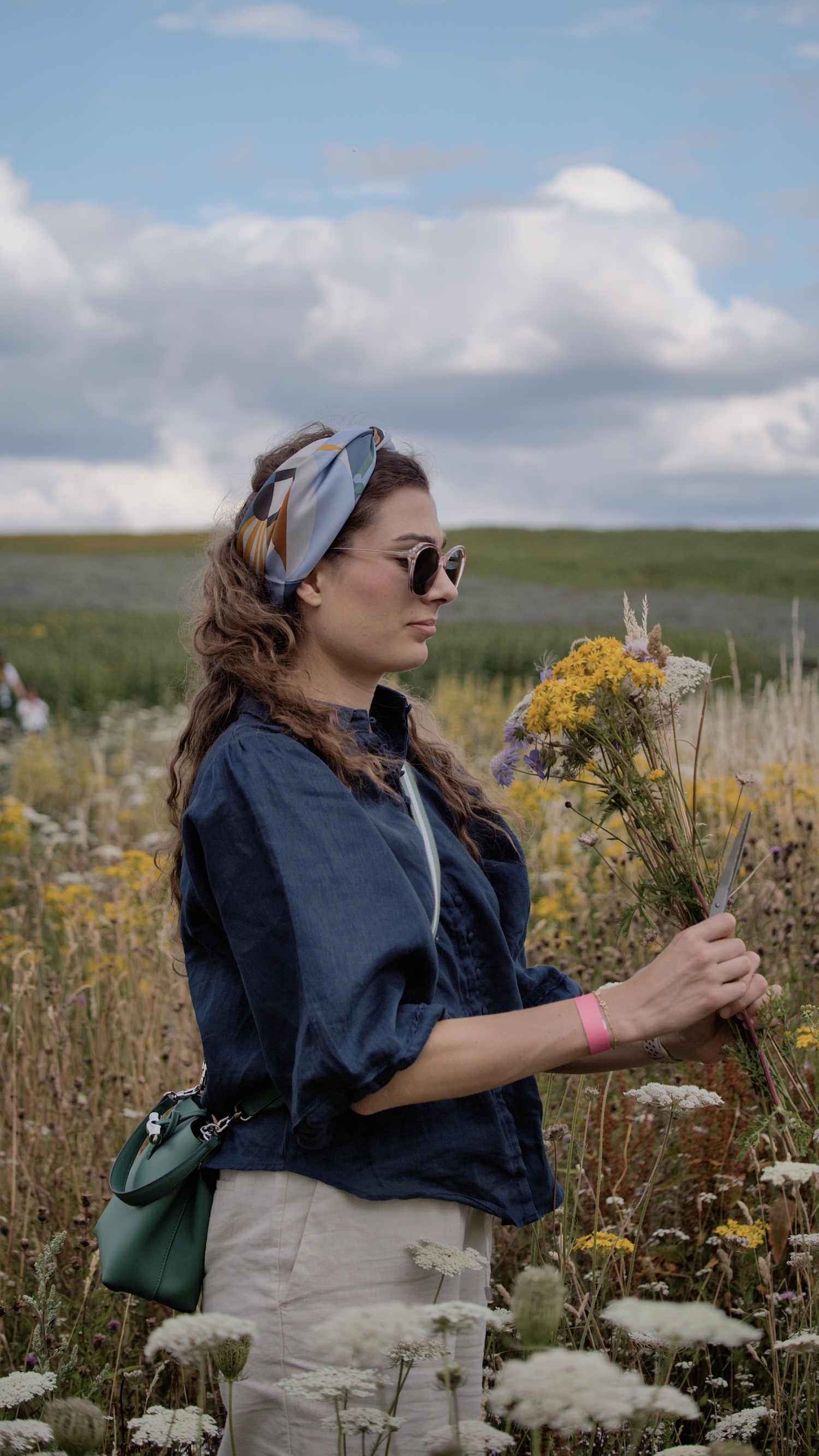 Holding a wildflower bouquet.